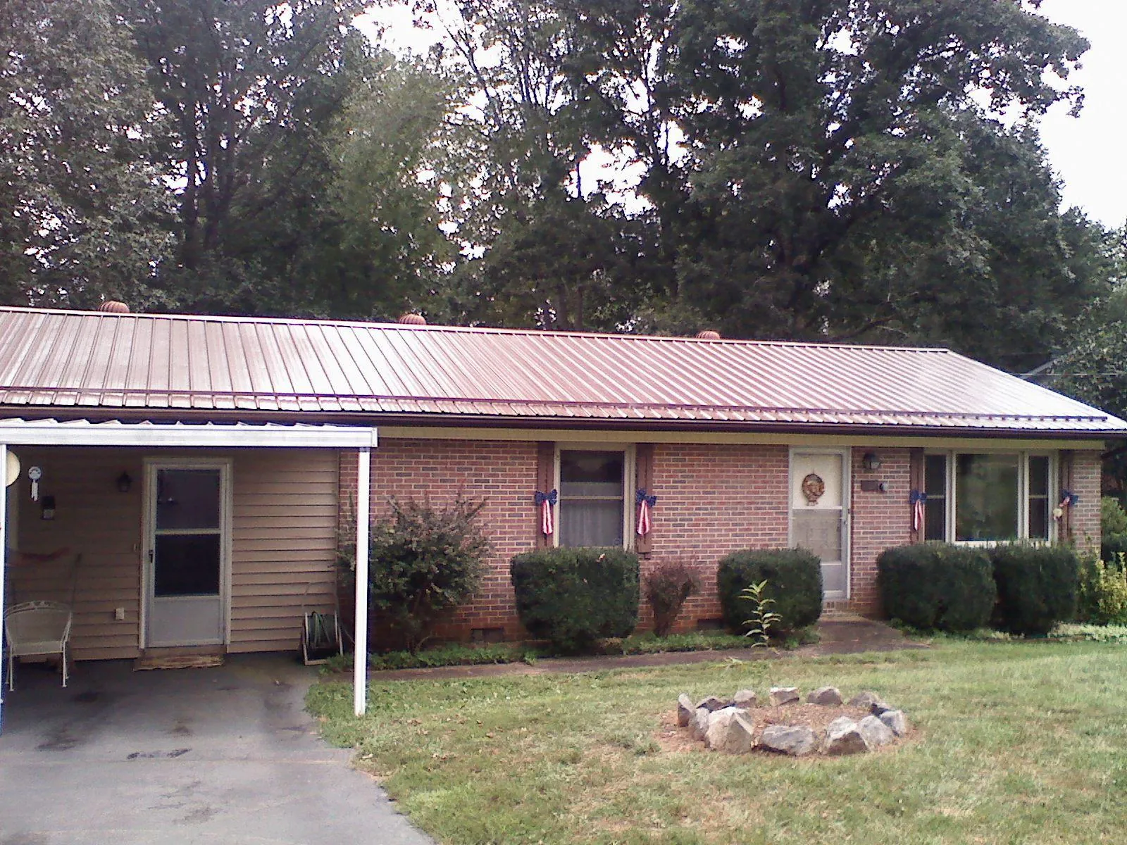 Bronze metal roof and carport on a brick ranch home — Roof Repair work by our crew in Manitou